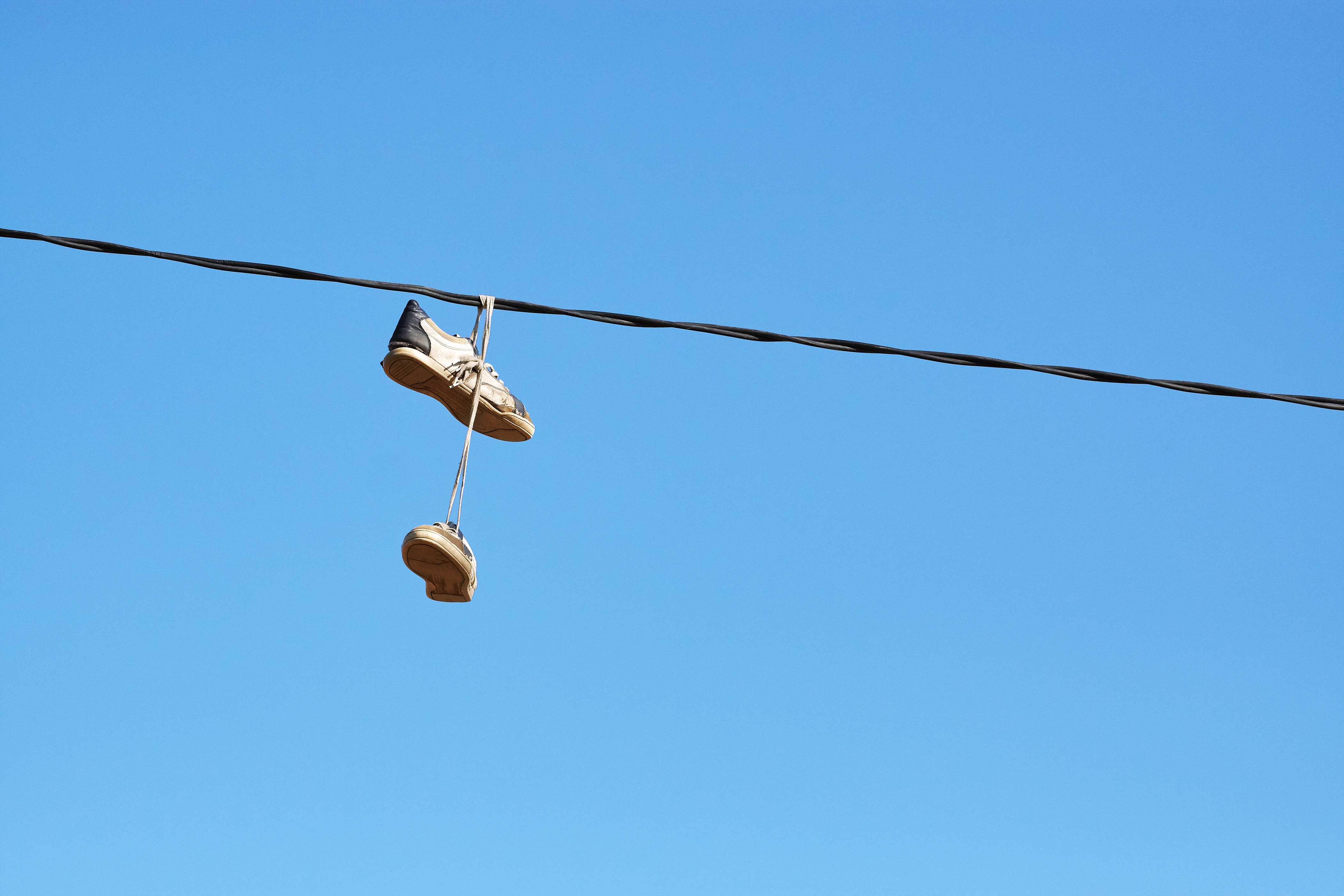 sneakers hanging from power lines